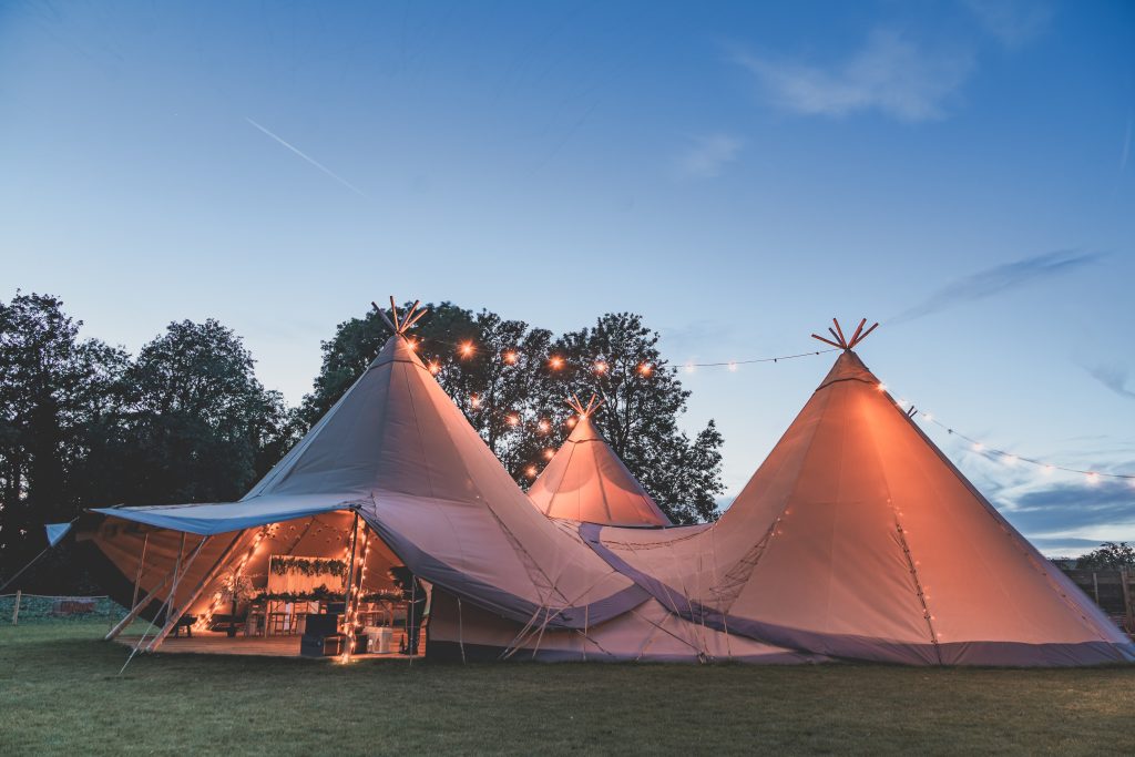Exterior shot of a wedding tipi at The Reid Rooms at dusk lit by festoon lighting. Exterior shot of a wedding tipi at The Reid Rooms at dusk lit by festoon lighting.