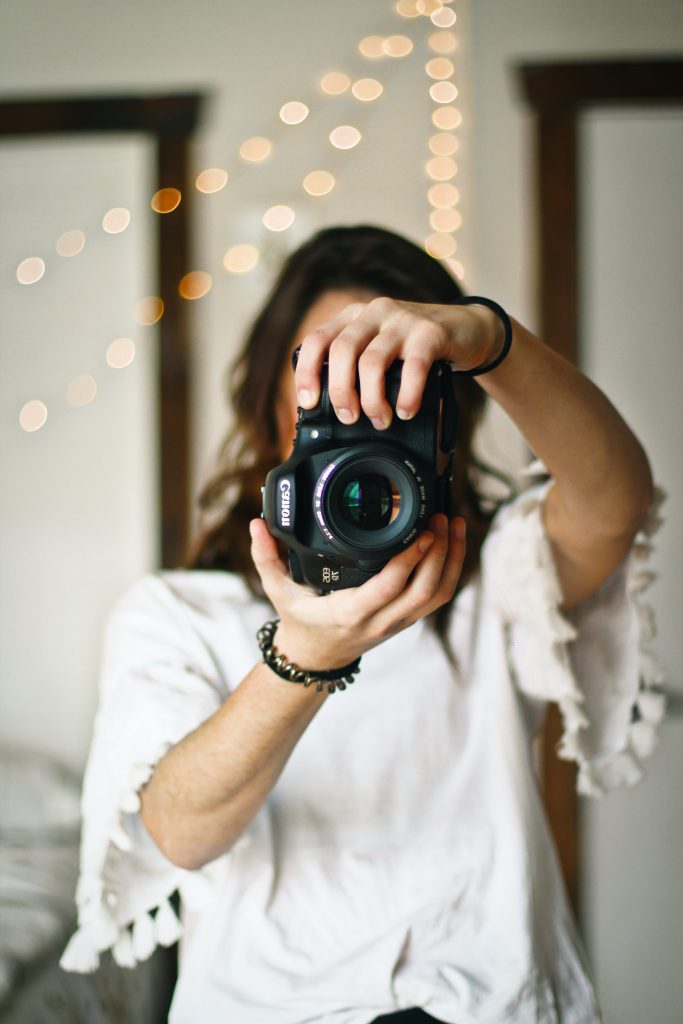 Link to a list of The Reid Rooms recommended suppliers for local photographers and videographers Close up on a female photographer holding a camera up to her face