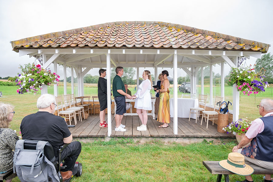 Just married couple walking away from the wedding pavilion located in a field at The Reid Rooms - David Tinkler Photography Outdoor wedding at The Meadow Pavilion. Photo courtesy of Eyebrow Photography