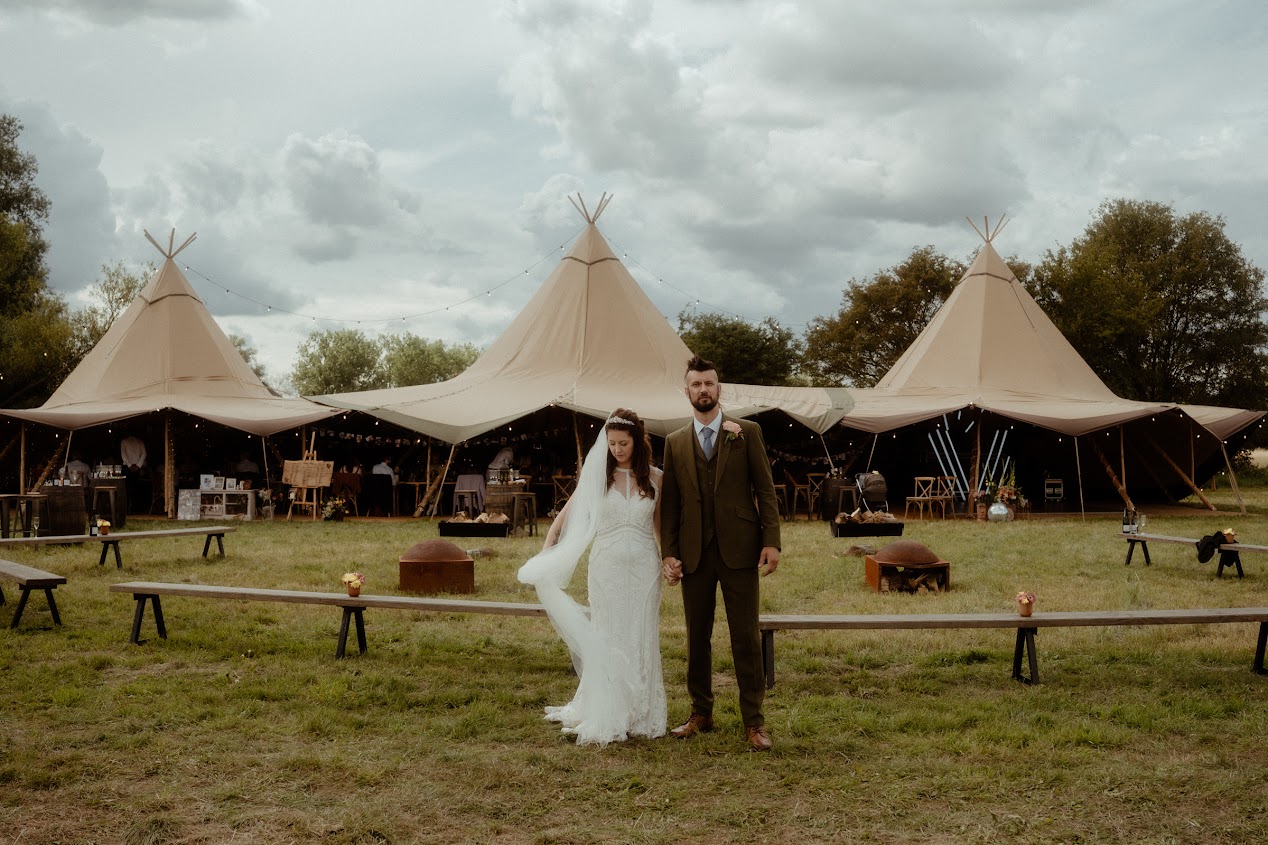 Just married couple walking away from the wedding pavilion located in a field at The Reid Rooms - David Tinkler Photography
